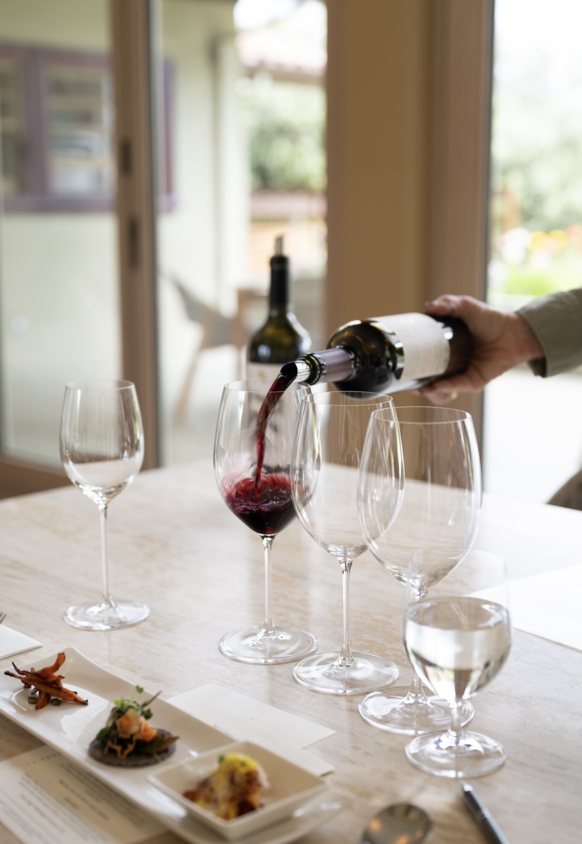 pouring wine in a glass for the tasting at trefethen in napa valley