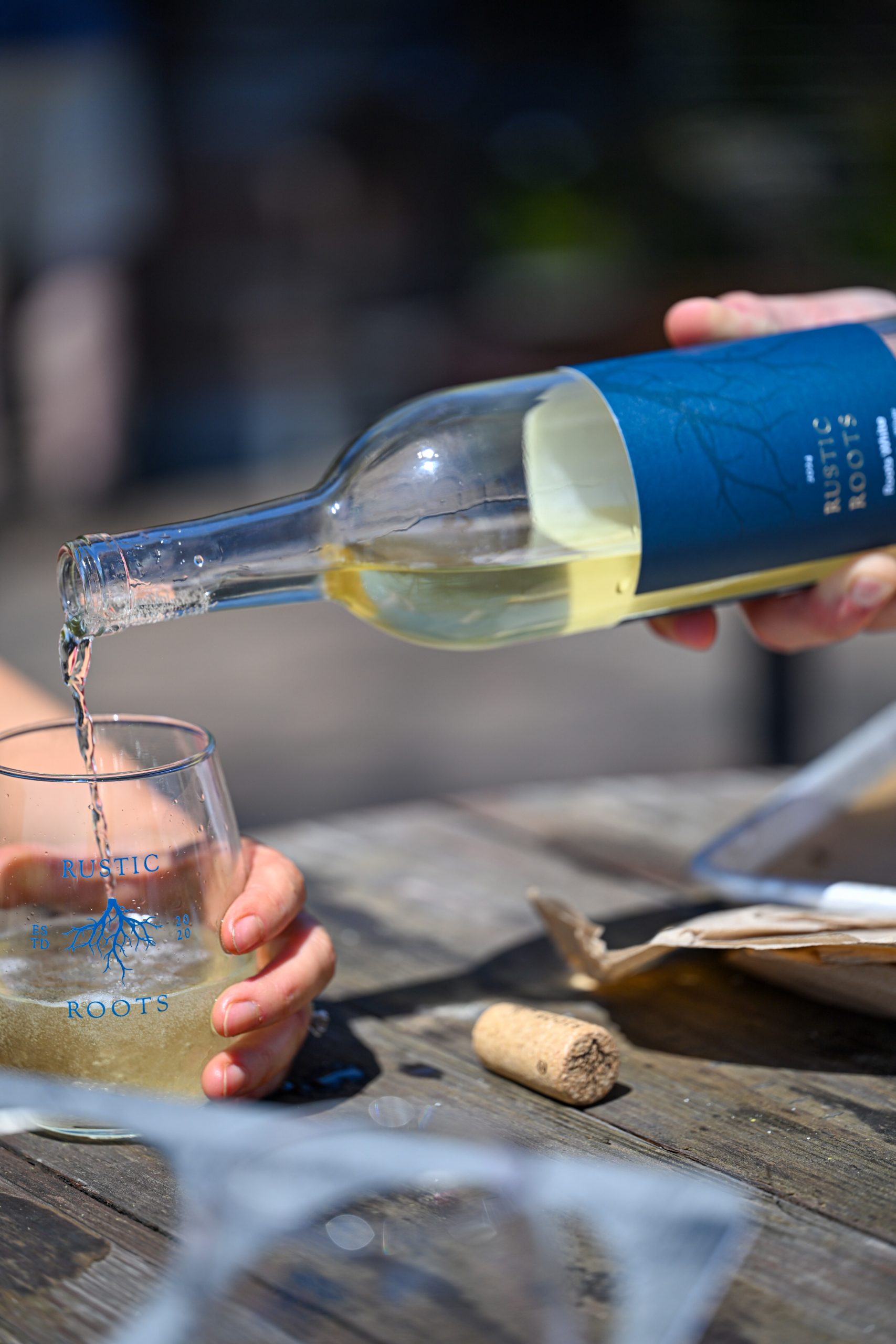 wine being poured into a glass at rustic roots