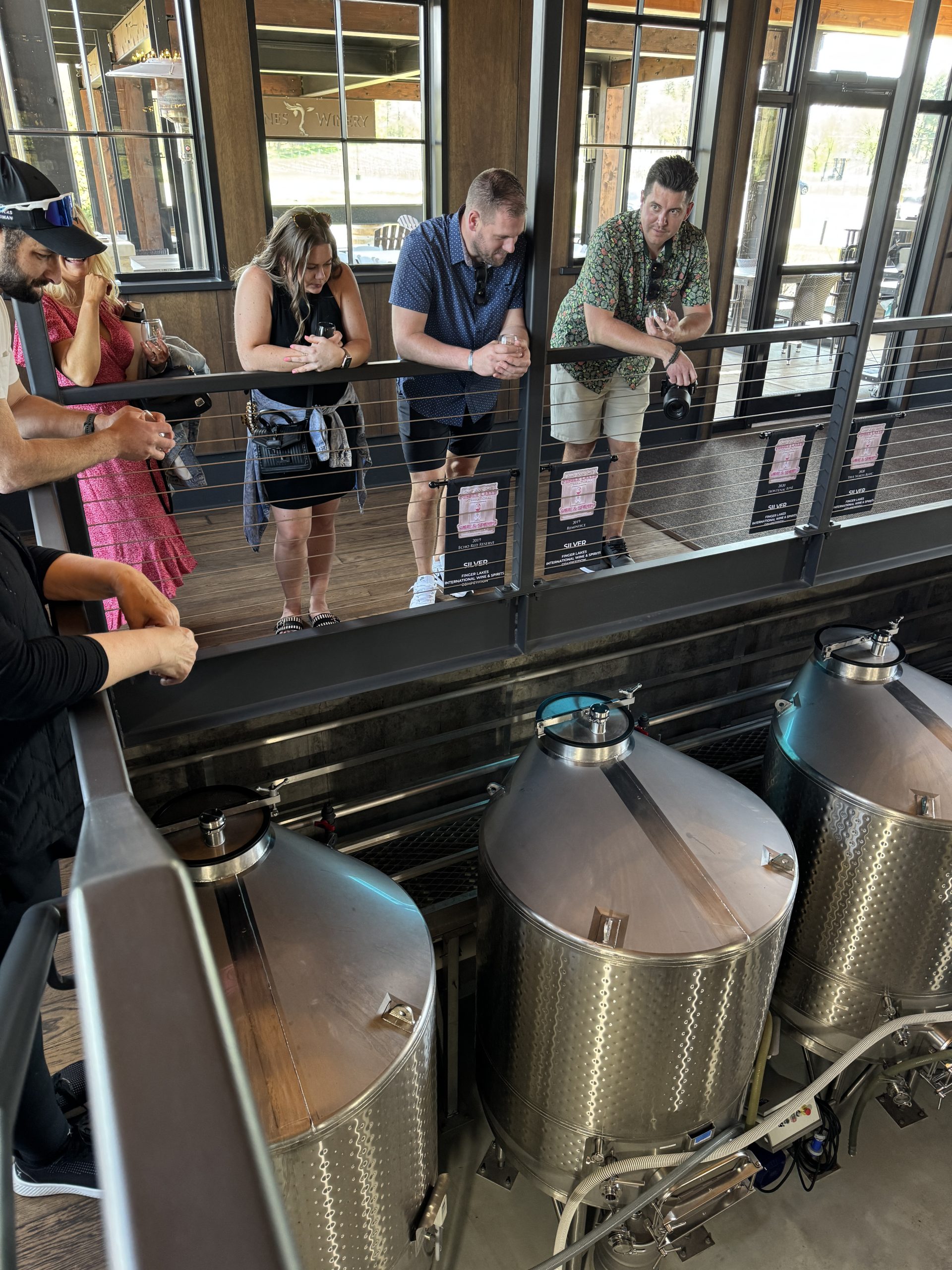group of friends overlooking the wine equipment where they make wine at 7 vines vineyard in dellwood, mn