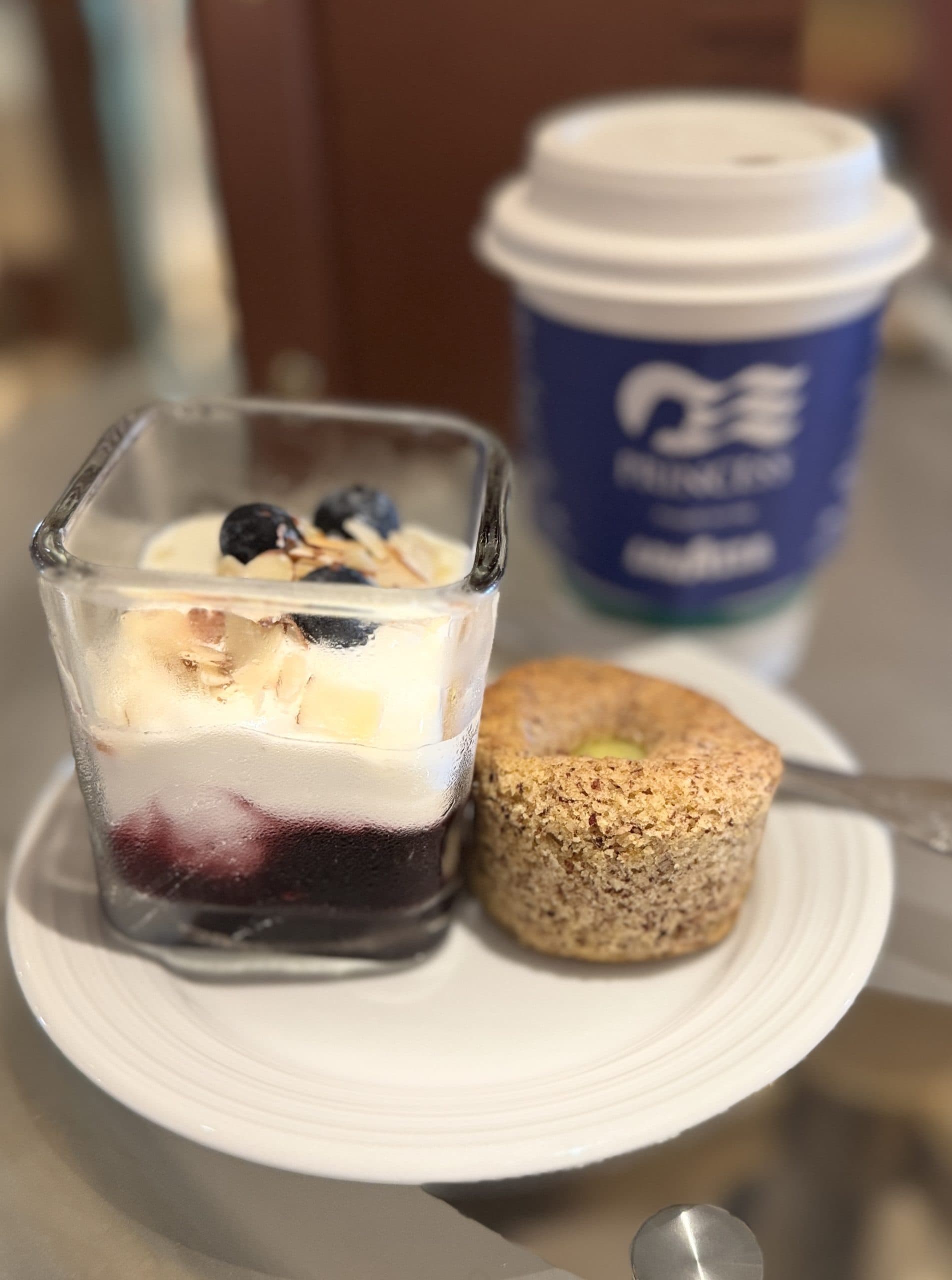enjoying a gluten free muffin and blueberry parfait with coffee on the royal princess cruise ship in alaska.