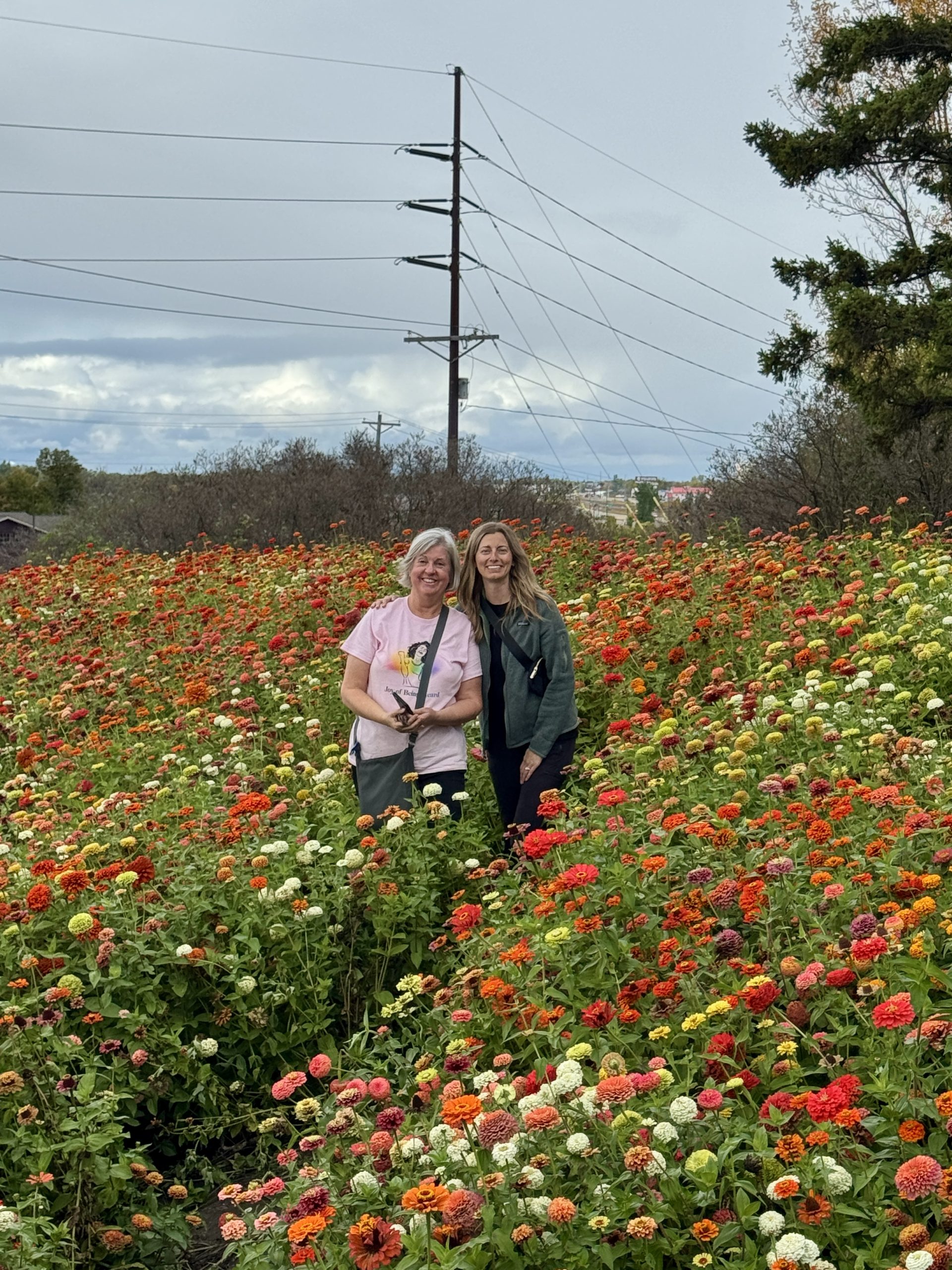 Jacki and Joni (mother-in-Law) standing in the bed of Zinnias