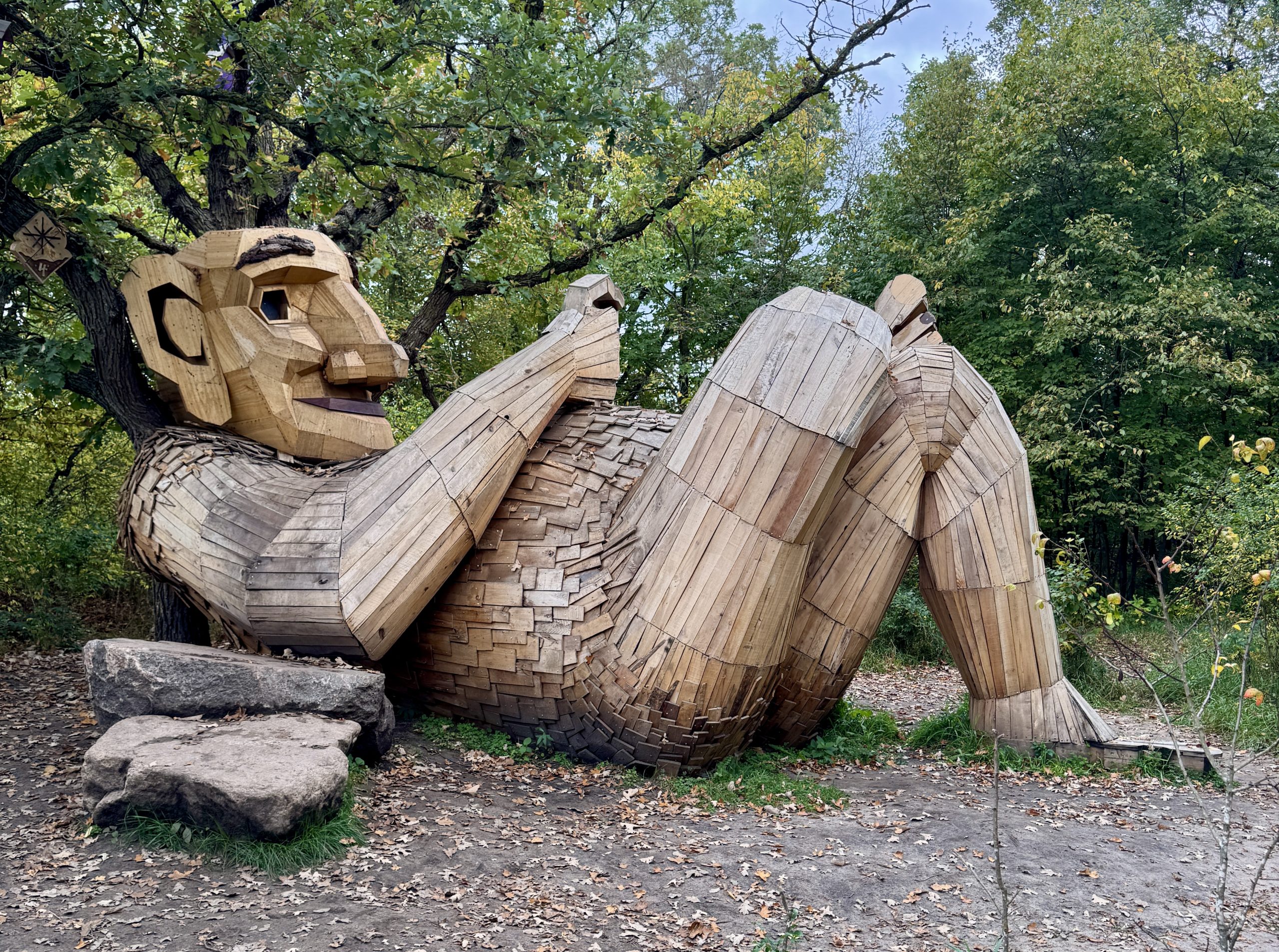 Jacob Everear Troll laying in a forest waiting to be told stories, part of Thomas Dambo display in Detroit Lakes, MN